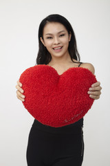 chinese woman hugging heart shape pillow
