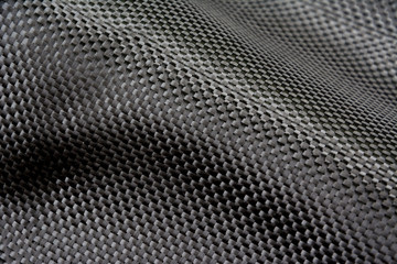 Black carbon fiber composite raw material close up background
