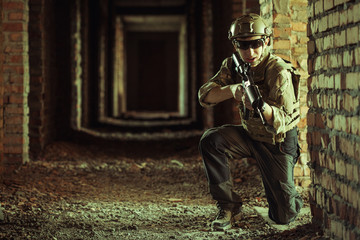 airsoft soldier with a rifle playing strikeball In brick building