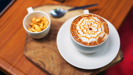 coffee latte art on wood table in cafe, selective focus top view