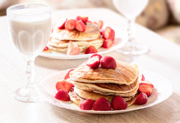 Tasty pancakes with strawberries and honey.