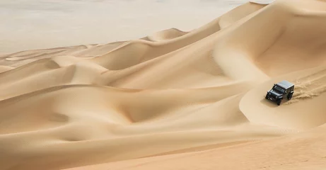 Photo sur Plexiglas car driving in Rub al Khali Desert at the Empty Quarter, in Abu Dhabi, UAE