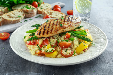 couscous salad with grilled chicken and asparagus on white plate. healthy food