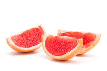 Three slices of grapefruit on a white background
