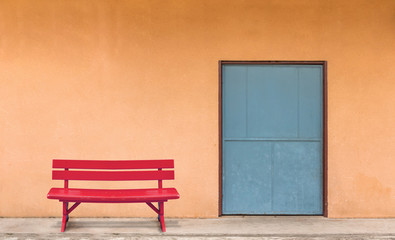The red bench was placed in front of the room with orange walls.