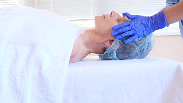 Spa therapy for elderly woman receiving facial mask. 4k. Slow motion. Reception of a cosmetologist