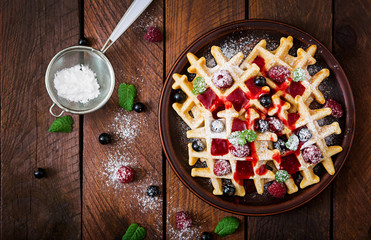 Belgium waffles with raspberries and syrup on a plate. Flat lay. Top view