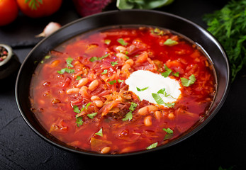 Traditional Ukrainian Russian borscht with white beans on the black bowl
