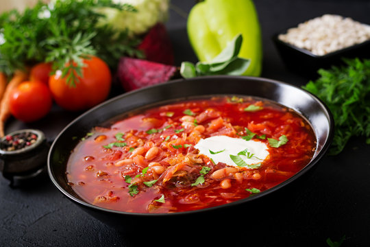 Traditional Ukrainian Russian borscht with white beans on the black bowl
