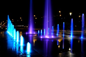 Fototapeta na wymiar City fountain hot summer night and colorful illuminations