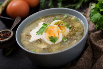 Green soup of sorrel in blue bowl.