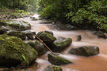 Scenic view of the river flow in the jungle. Long exposure shot. Smooth water jets flows on stones. Mahua waterfall, Borneo island, Sabah, Malaysia