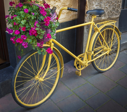 Yellow bicycle with flower basket