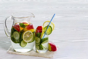 Detox water with cucumber and lemon with Apple in itcher and glass