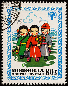 Children in Mongolian national clothes with flowers on postage stamp