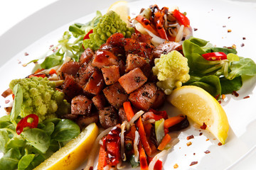Grilled sausages with vegetables on white background