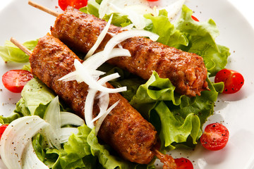 Kebabs - grilled meat and vegetables on white background 