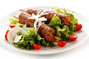 Kebabs - grilled meat and vegetables on white background 