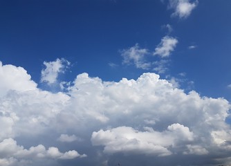 Big huge white puffy cloudy  clouds forming over blue sky