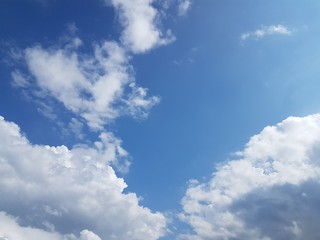 View of white puffy clouds on clear day with blue sky background