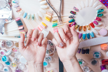 Nail art concept. Woman making decoration on the nails on white table