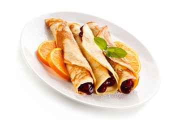Crepes with cherries and cream on white background 