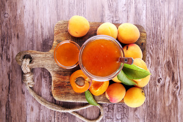 Apricot jam in glass bowl with fruit around
