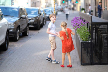 Boy and girl on the street near coffee tables