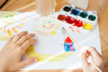 Girl painting with paintbrush and colorful paints