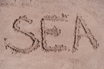Stars of pin code drawn on brown sand on the beach in sunny day