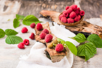 Raspberry on a tree bark and in the bowl