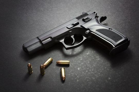 Handgun with ammunition on dark background