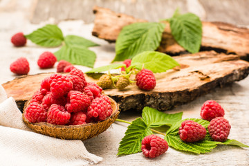 Raspberry in a bowl, berries and leaves on a shabby  wood