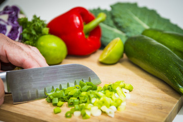 Green onions food prep chopping slicing fresh healthy colorful vegetables produce cutting board knife on white background
