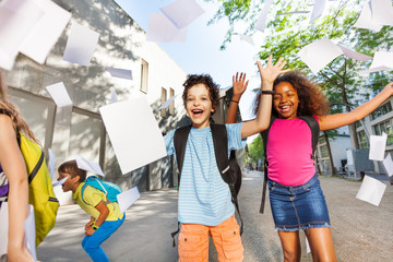 Boy with friends joy screaming throwing papers up