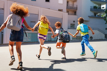 Kids with backpacks run to school © Sergey Novikov
