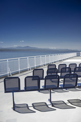 Seating and Western view of clear blue sky and the Strait of Georgia from the top deck of a passenger and vehicle ferry enroute from Tsawwassen to Victoria, BC, Canada.