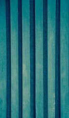 Texture of turquoise weathered vertical wooden lining boards with gap. 