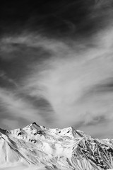 Black and white winter snowy mountains at windy day