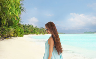 Beautiful young woman on sea beach at tropical resort