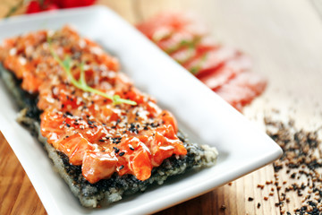 Fillet of salmon with rice and sesame seeds on table