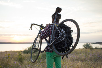 photo of bicycle rider outdoor in fields during the summer sunset in lake  