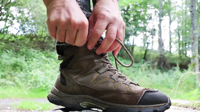 A man tucks shoelaces into his shoes.