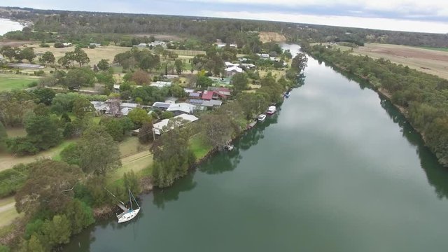 Backward low flight over Silt Jetty and water canal at Mitchell River Gippsland Lakes reserve in Australia