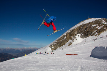 A male skier jumping over an obstacle in the Kitzsteinhorn Funpark in the alps of Austria