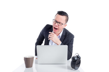 Young asian businessman wearing black suit yawning while working with notebook computer over white background