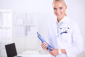 Woman doctor standing with folder at hospital