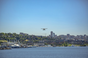 Fototapeta na wymiar Float plane taking off above the buildings