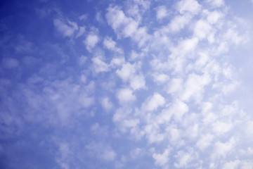 Deep blue sky with tiny clouds, small clouds in blue sky.