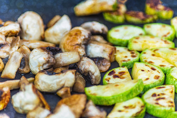 cooking mushrooms and vegetables on the grill, background with a bokeh effect